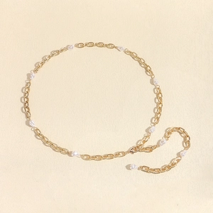 Detail of a gold-tone waist chain featuring elegant baroque imitation pearls and metal links