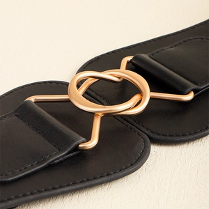 Detailed close-up of wide black leather belt with golden metal interlaced rings buckle