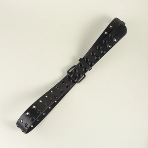 Détail de la ceinture noire punk Y2K avec double rangée d'œillets métalliques et boucle
