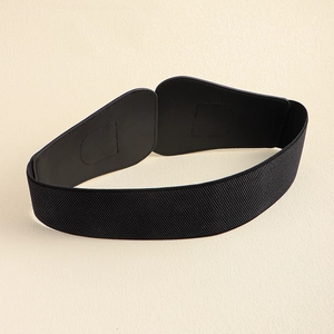 Macro view of wide black elastic waist belt with sleek leather panel for dresses