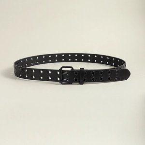 Détail de la ceinture en cuir noir à double œillets avec boucle métallique à double ardillon
