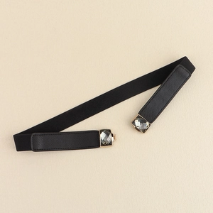 Détail d'une ceinture élastique noire ornée de cristaux gris et d'un bord doré chic