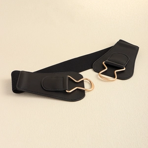 Close-up of golden metallic irregular ring buckle on black elastic waist belt
