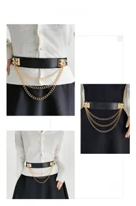 Detail of black elastic corset belt with triple layered gold metal chains and studs