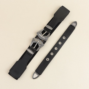 Gros plan d'une ceinture noire vintage avec deux boucles gravées et des œillets en métal