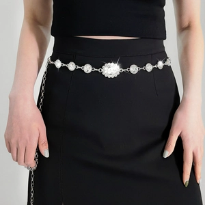 Detail of silver chain belt with shimmering rhinestones on a black skirt dress