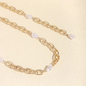 Nahaufnahme der goldenen Kette mit Barockperlen für Kleider und Strand-Looks
