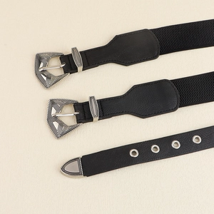 Détails des boucles argentées gravées et des textures de ceinture en cuir noir