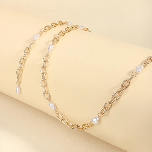 Detailansicht der goldfarbenen Metallkette mit eleganten weißen Barockperlen für Damen