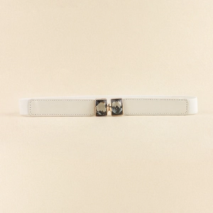 Détail de la ceinture élastique blanche avec pierres grises et boucle dorée élégante