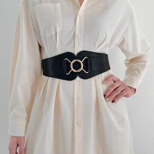 Close-up of elegant black elastic waist belt with a golden interlocking metal ring buckle
