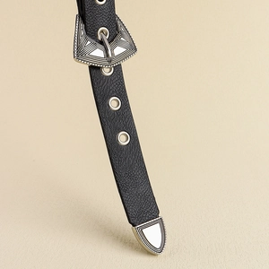 Gros plan sur ceinture en cuir noir vintage avec boucle argentée ornée et pointe gravée