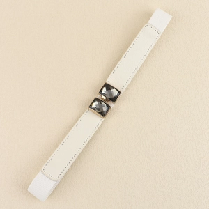 Détail de la ceinture élastique blanche avec boucle dorée et pierres grises