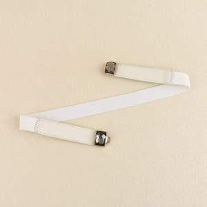 Détail d'une ceinture élastique blanche avec boucle carrée en cristal gris et bordure dorée
