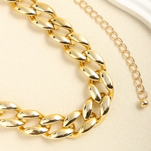 Close-up of chunky gold waist chain with polished metal links and adjustable ball charm