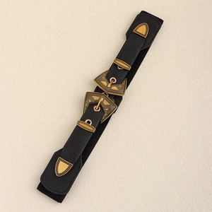 Vue détaillée de la ceinture vintage noire avec des boucles dorées gravées de motifs