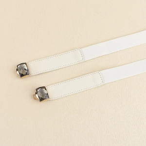 Détail de la ceinture élastique blanche avec boucle dorée et pierre précieuse grise