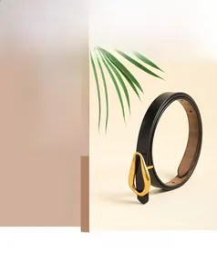 Vue détaillée d'une ceinture en cuir noir avec une boucle métallique dorée en goutte