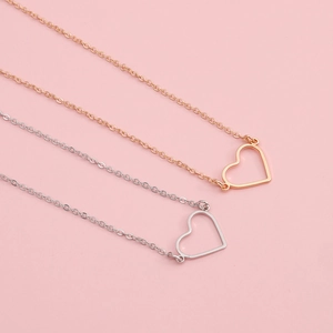 Vista dettagliata dei ciondoli a cuore traforati in oro rosa e argento su catene sottili