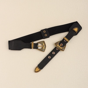 Détail macro de la boucle métallique dorée gravée sur la ceinture élastique noire pour femmes