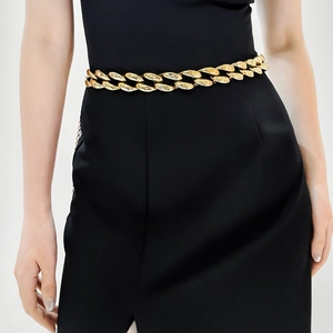 Detailed view of heavy-duty gold hollow metal chain belt on a black dress waist