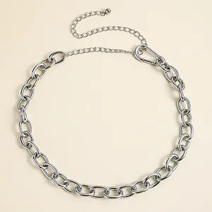 Detail view of a silver metal chain belt with thick links and an adjustable lobster clasp