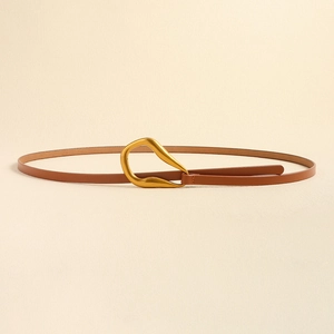 Détail d'une fine ceinture en cuir marron avec boucle métallique dorée mate irrégulière