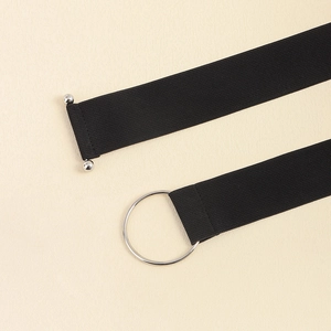 Close-up of black elastic belt featuring a silver metal ring and bar buckle closure