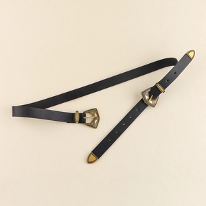 Détails de boucles dorées vintage avec gravures complexes sur une ceinture en cuir noir