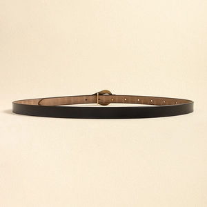 Détail d'une fine ceinture en cuir noir avec boucle à ardillon en laiton vintage et trous ajustables