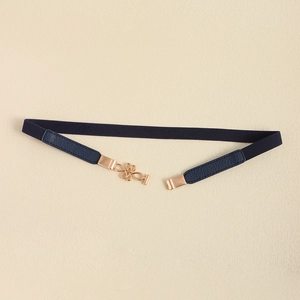 Detailed macro view of the navy blue elastic belt with rose gold knot buckle