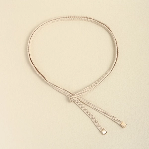 Close-up of beige woven waist rope with elegant square gold metal end tips