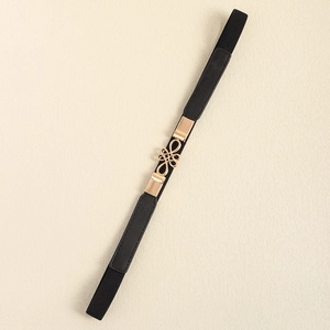 Close-up of black elastic waist belt with an intricate gold Chinese knot metal buckle