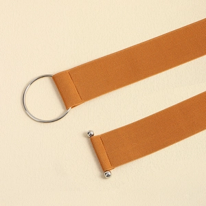 Macro shot of the orange elastic woven belt with silver metal ring and T-bar buckle closure