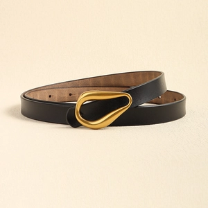Détail de la ceinture fine en cuir noir avec une boucle dorée élégante en forme de goutte