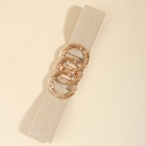 Close-up of golden interlocking rings buckle on khaki elastic belt for women