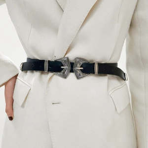 Gros plan sur ceinture vintage en cuir noir avec double boucle sur blazer blanc