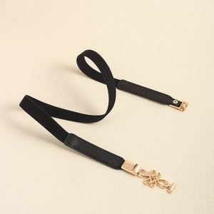 Detail view of black elastic waist belt with a golden Chinese knot alloy buckle