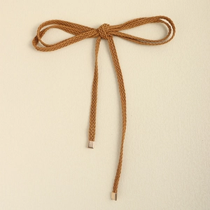Close-up of brown braided knot belt with elegant golden metal ends for dresses