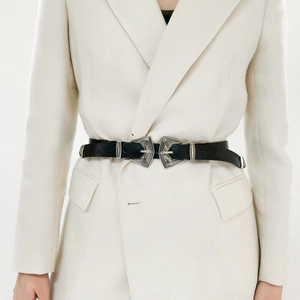 Détail d'une ceinture en cuir vintage à double boucle gravée argentée sur une veste