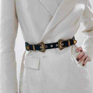 Détail de la boucle en métal gravé vintage sur une ceinture en cuir noir pour femme