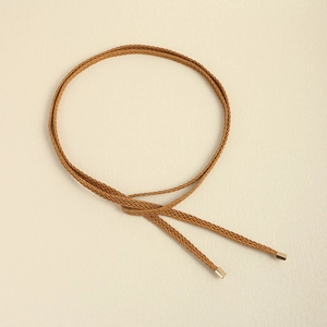 Close-up of caramel woven braided waist belt with gold square metal tips on white background