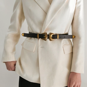 Vue détaillée de la ceinture en cuir noir à double boucle dorée antique sur un blazer