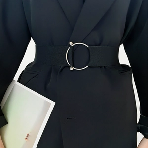 Close-up of black elastic waist belt featuring a large silver metal ring with rhinestones