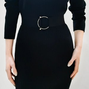 Close-up of black elastic waist belt with silver round buckle and rhinestone detail