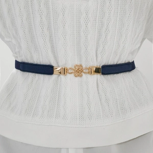 Close-up of gold Chinese knot buckle on dark blue elastic skinny belt for women