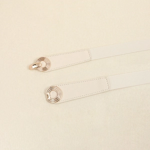 Close-up of beige elastic waist belt with elegant interlocking gold ring buckle detail