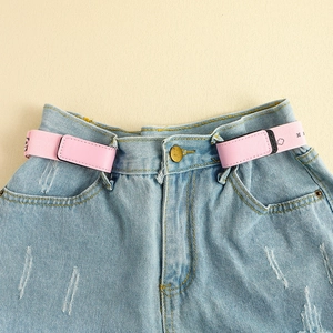 Detail eines rosa schnallenlosen elastischen Kindergürtels an hellblauer Jeanshose