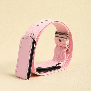 Detail eines rosa elastischen Kindergürtels mit schwarzen Sternen und silberner Schnalle