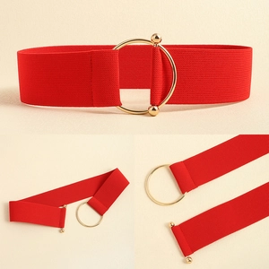 Detail view of bold red elastic waist belt with large circular gold metal buckle for women